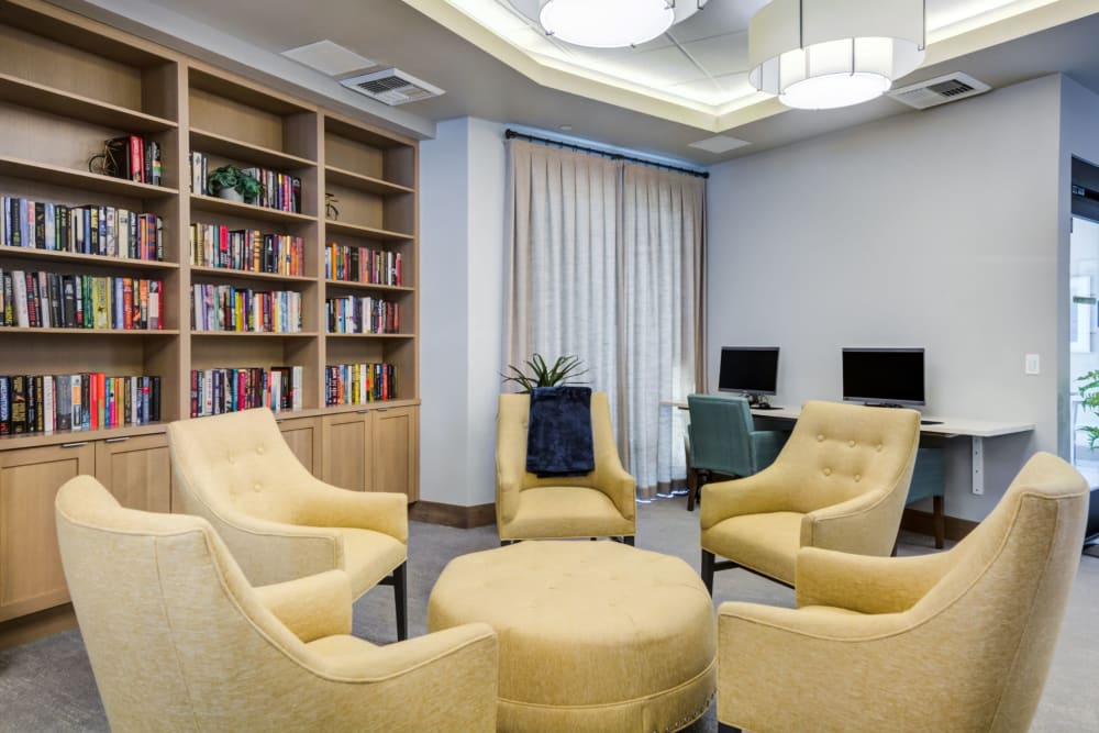 A cozy reading area with yellow chairs and bookshelves nearby.