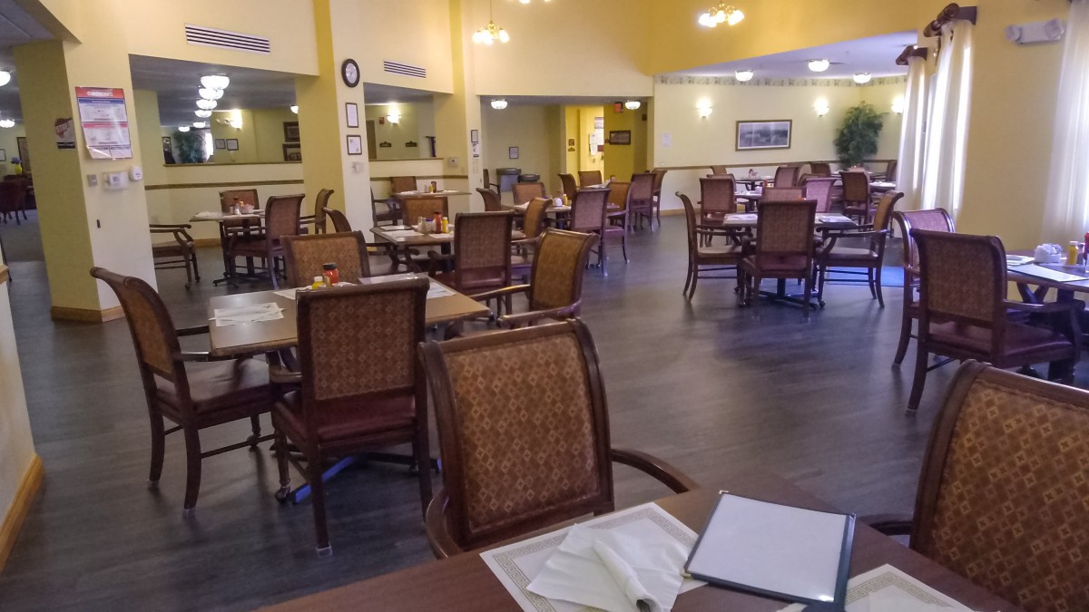 An empty restaurant dining area with neatly arranged tables and chairs.