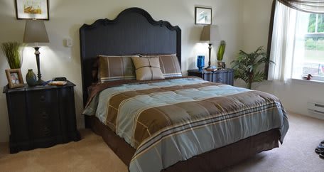 A well-decorated bedroom with a neatly made bed and stylish decor.