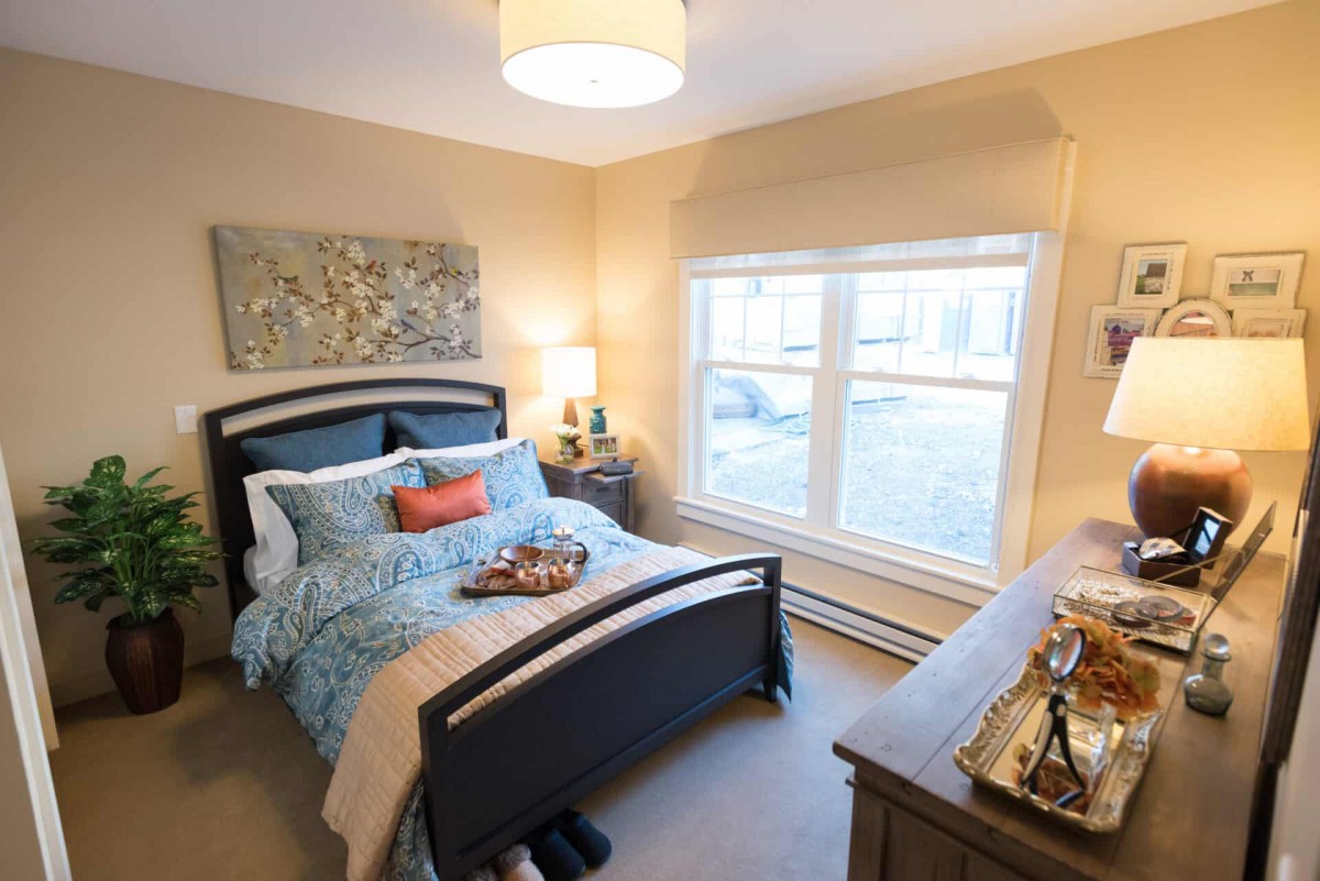 A cozy bedroom with modern decor, featuring a comfortable bed and large window.