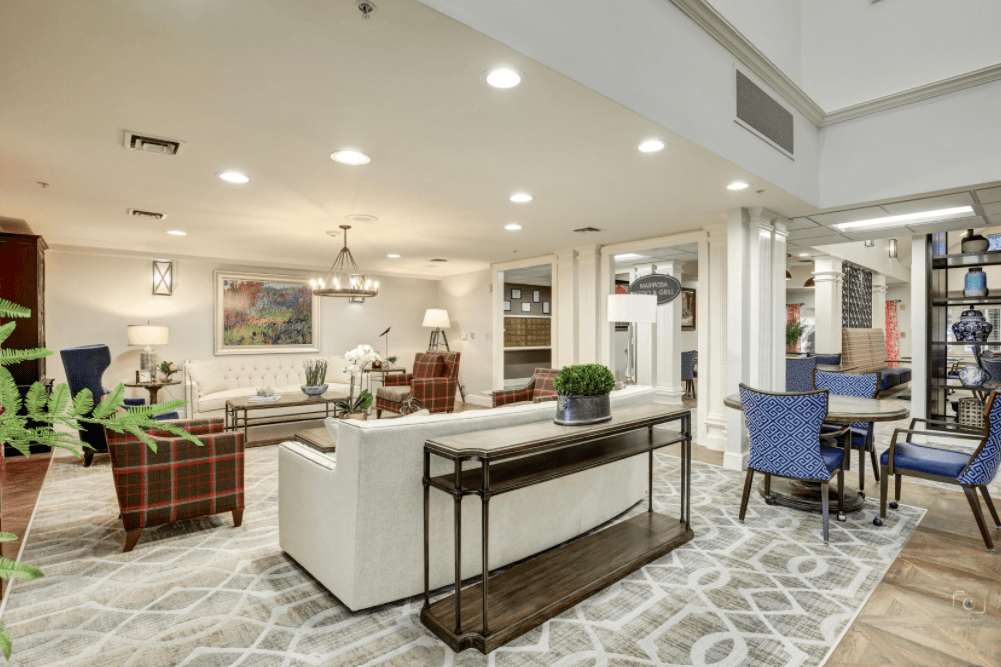 A spacious and elegantly designed living room with modern furniture and bright lighting.