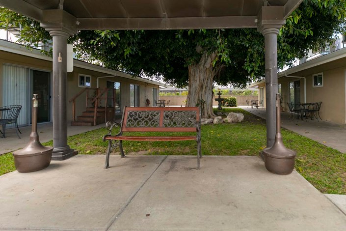 An outdoor bench on a patio with a garden view.