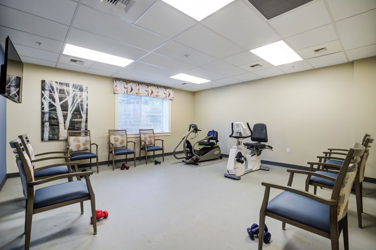 A physical therapy room equipped with exercise machines and seating.