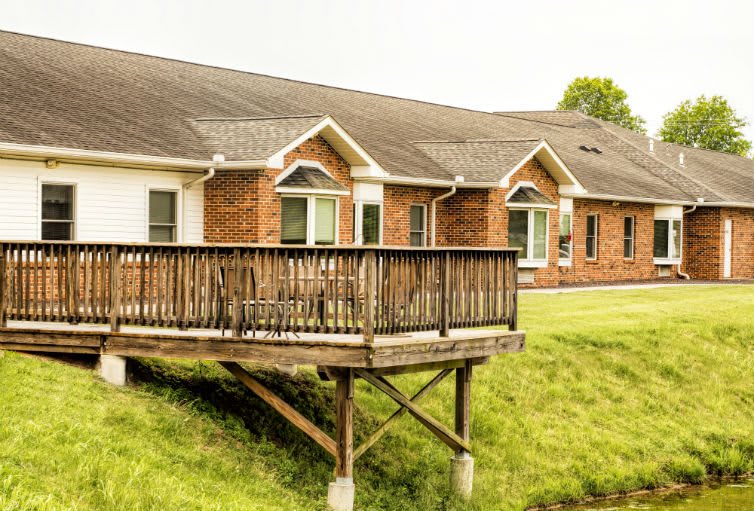 A brick residential house with a wooden deck.