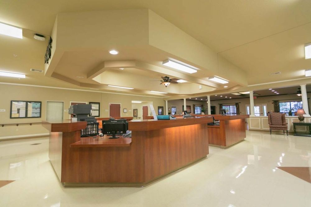 A spacious reception area with multiple desks and computers, illuminated by ceiling lights.