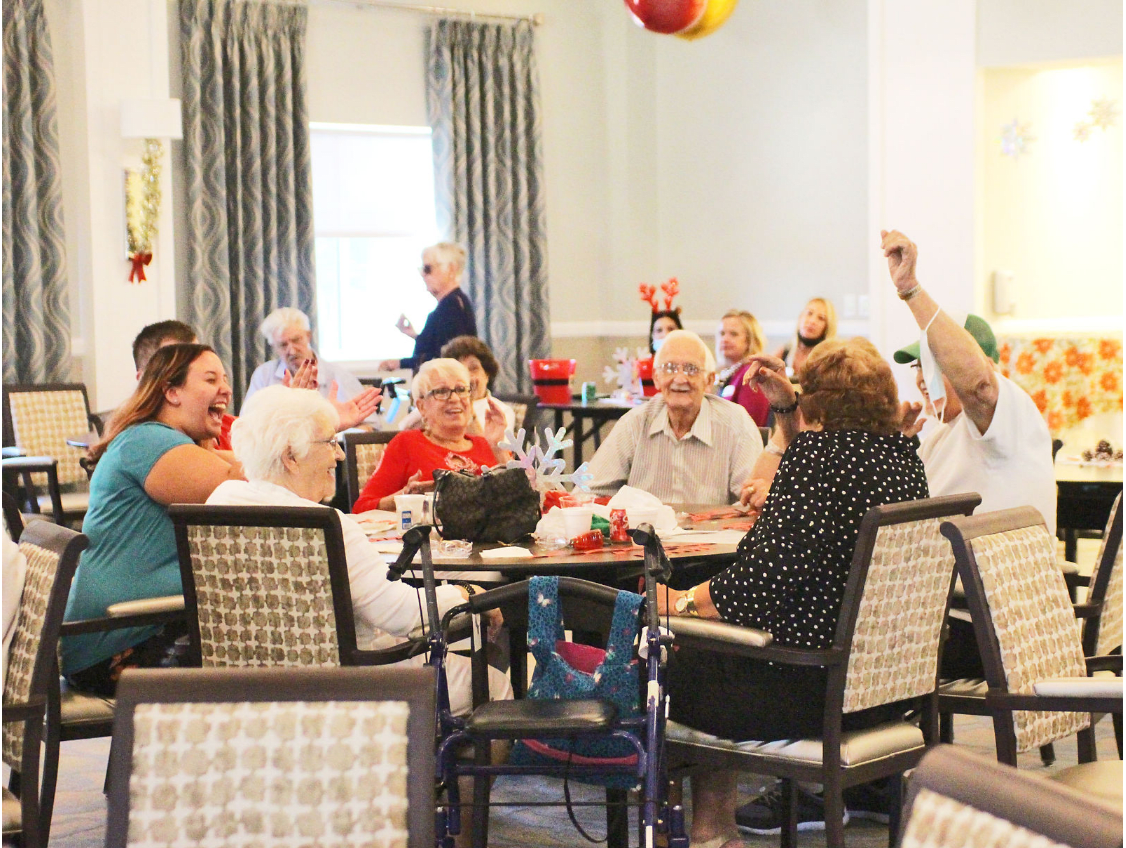 A cheerful group of seniors enjoying a social activity indoors.