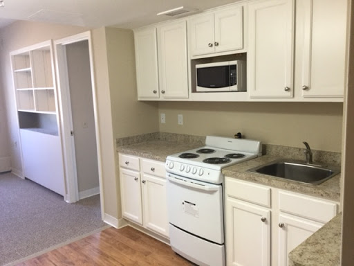 A modern kitchen with white cabinetry and essential cooking appliances.