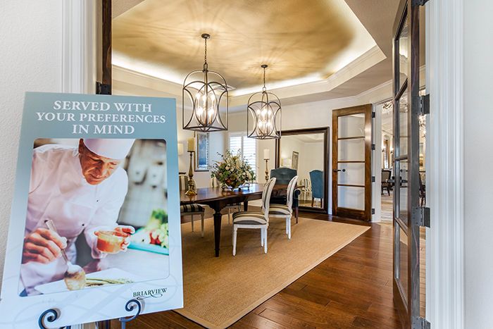 A beautifully designed dining room with chandeliers and a stylish advertisement poster in the foreground.