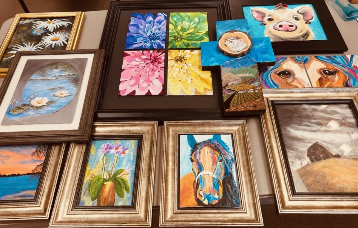 A collection of colorful framed paintings featuring flowers, animals, and abstract designs.