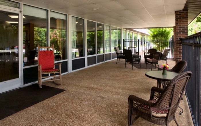 A cozy patio area with comfortable seating and large glass windows.