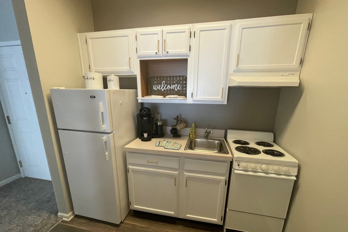 Compact kitchen setup with white cabinetry and essential appliances.