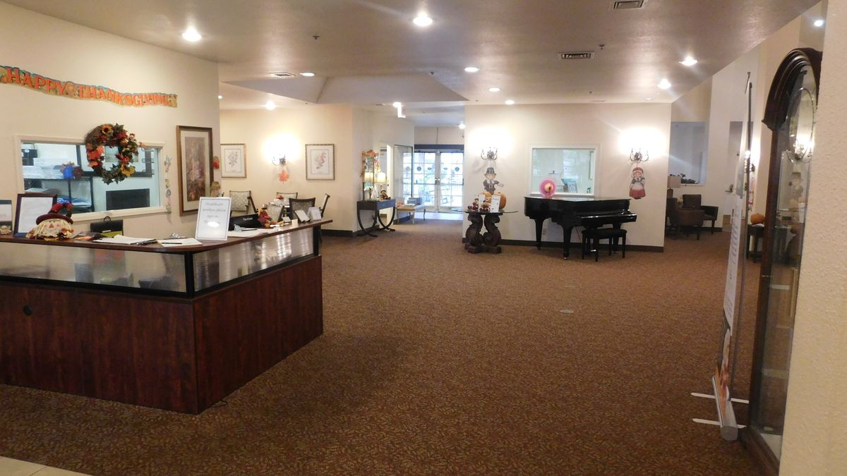 Spacious lobby area with a piano and reception desk.