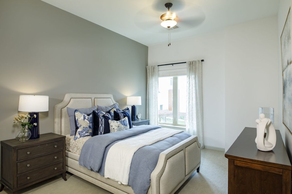 A modern bedroom with elegant decor, featuring a comfortable bed and ample natural light.