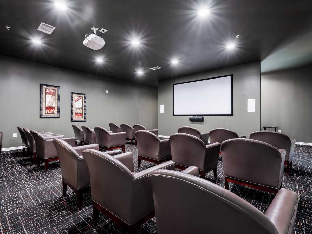 A modern home theater with comfortable seating and a large projector screen.