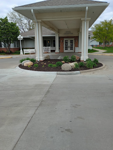 An inviting entrance to a building, featuring landscaped gardens and smooth concrete pathways.