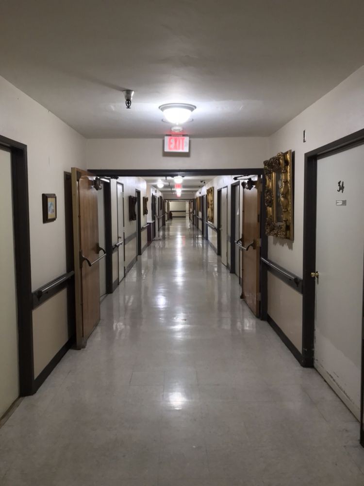 A long, well-lit hallway with multiple doors.