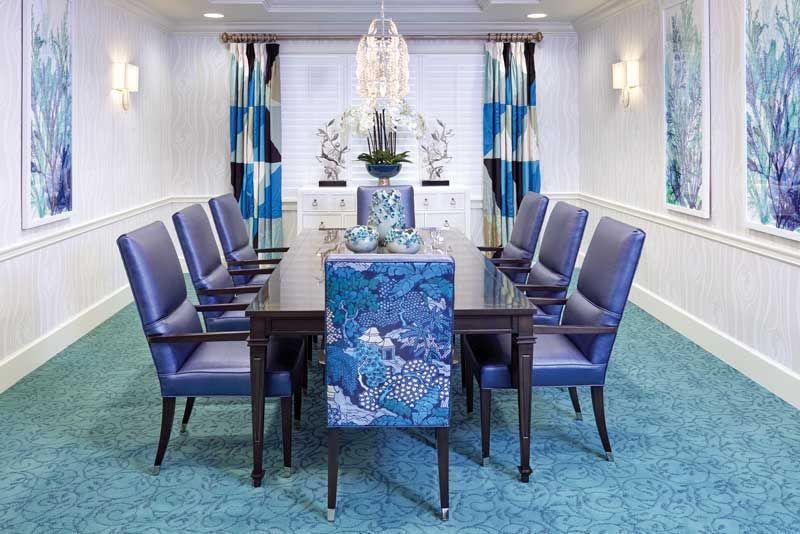 A modern dining room with blue chairs and elegant decor.