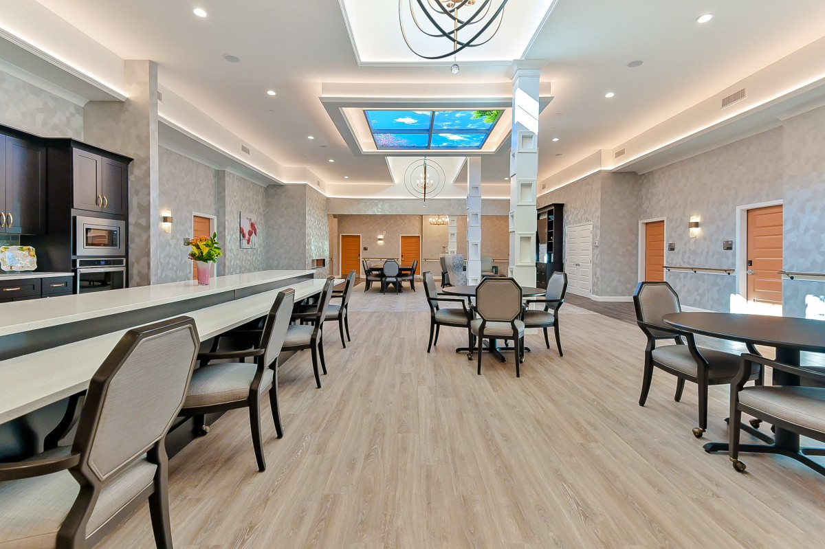 A spacious modern dining area with elegant furnishings and stylish lighting fixtures.