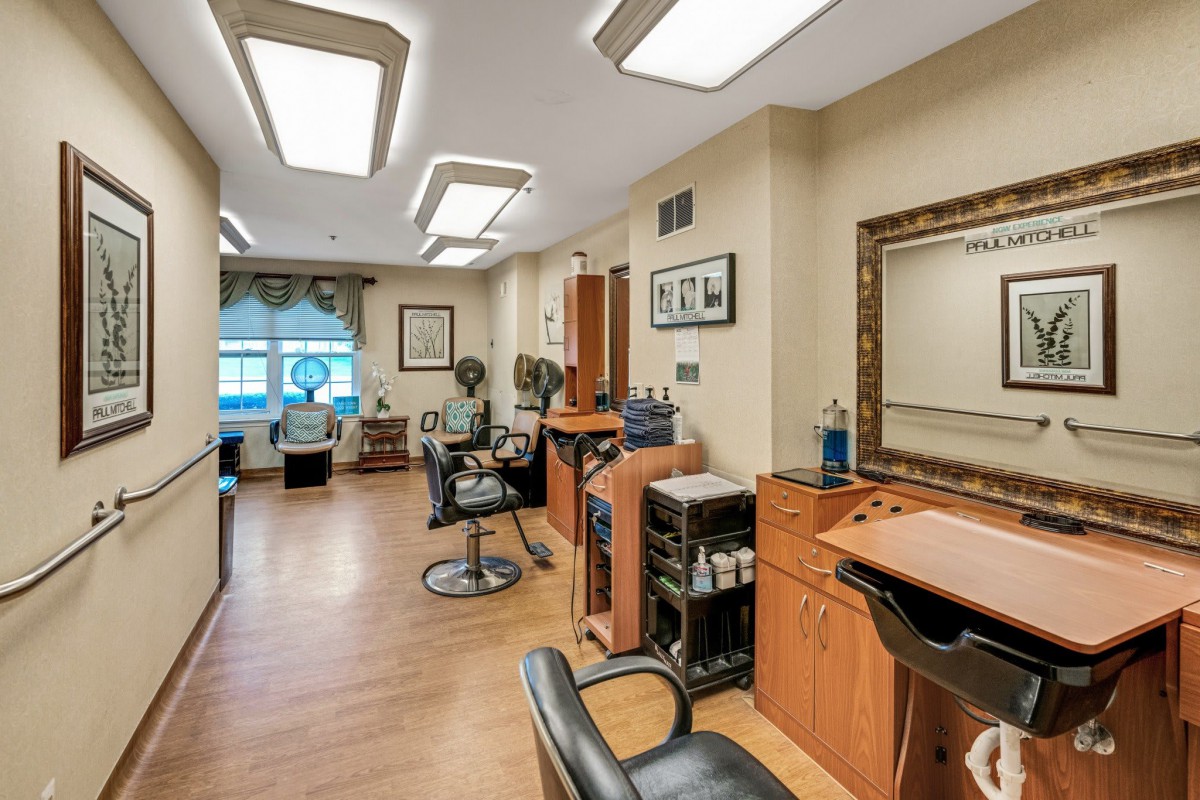 A well-lit, modern hair salon interior with multiple workstations and seating.