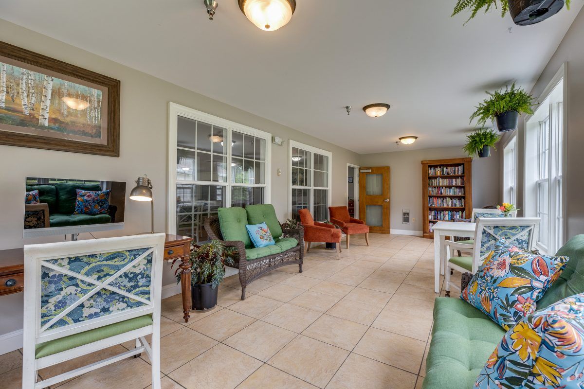A cozy indoor lounge area with various seating options, a bookshelf, and decorative elements.