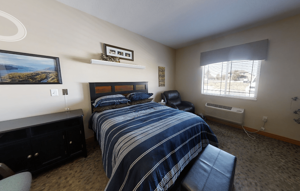 A cozy bedroom with a neatly made bed featuring striped bedding.