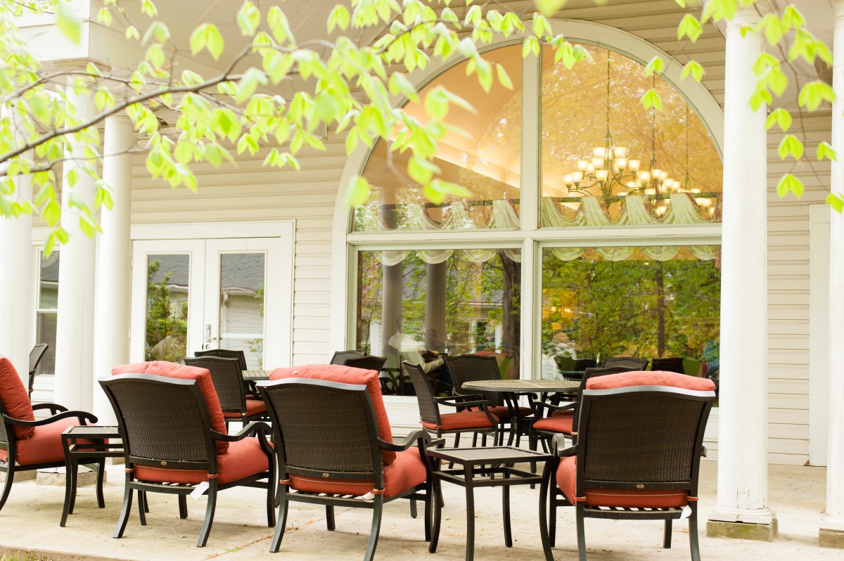 An inviting outdoor patio area with comfortable seating and large windows.