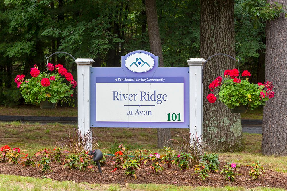 Entrance sign for River Ridge community, surrounded by flowers and greenery.