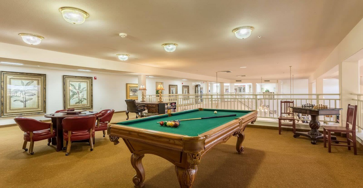 A spacious game room featuring a billiards table and seating area.
