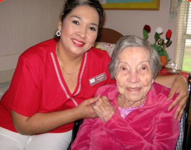 A caregiver and an elderly woman share a warm moment together, showcasing the bond of companionship in healthcare.
