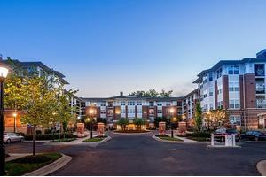 A modern apartment complex with well-maintained landscaping and an inviting entrance during the evening.
