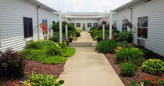 A beautifully landscaped garden walkway leading to a building entrance.
