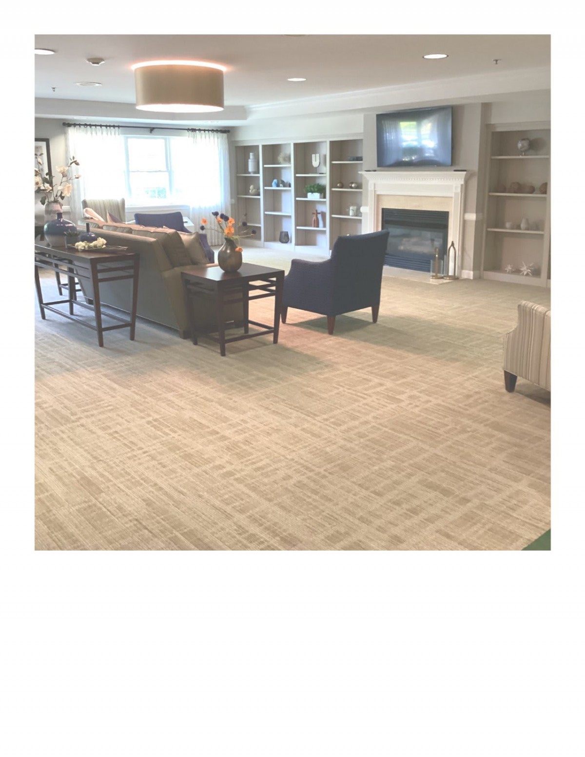 A spacious living room with comfortable seating and a fireplace.