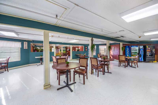 A spacious indoor dining area featuring wooden tables and chairs, perfect for community gatherings.