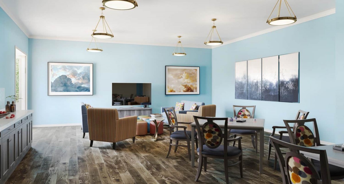 A modern and cozy living room with blue walls, featuring comfortable seating, a television, and decorative artwork.