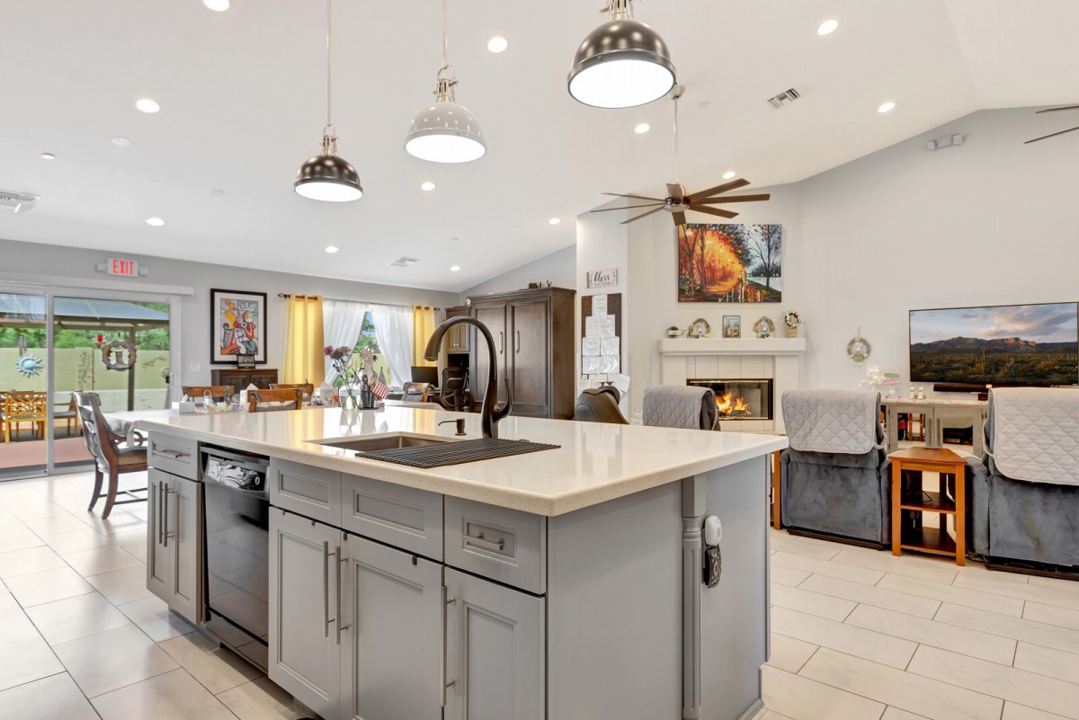 A modern open-plan kitchen with a central island and stylish lighting fixtures.