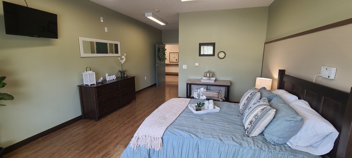 A modern minimalist bedroom with a neatly made bed and stylish decor.