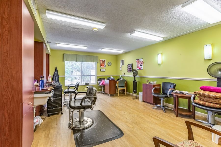 A brightly lit hair salon with multiple styling stations and chairs.