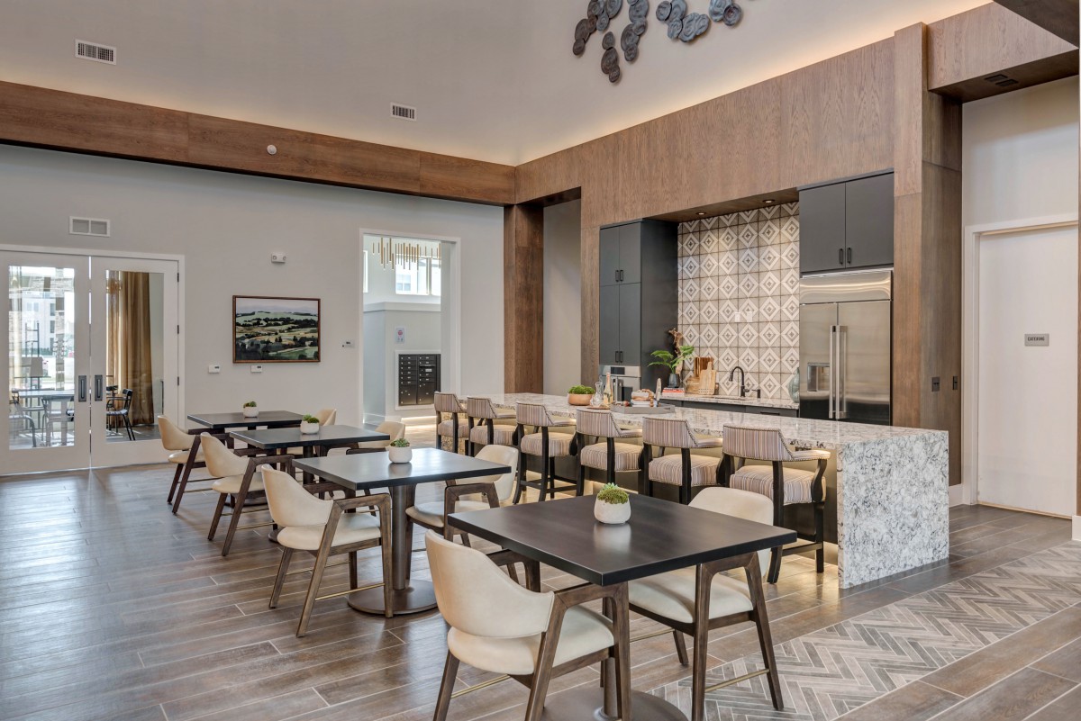 A modern dining area with wooden tables and chairs featuring a sleek interior design.