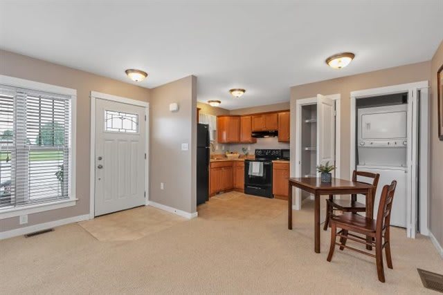 A cozy open floor plan featuring a kitchen with wood cabinets, modern appliances, and an adjacent dining area with a table and chairs.