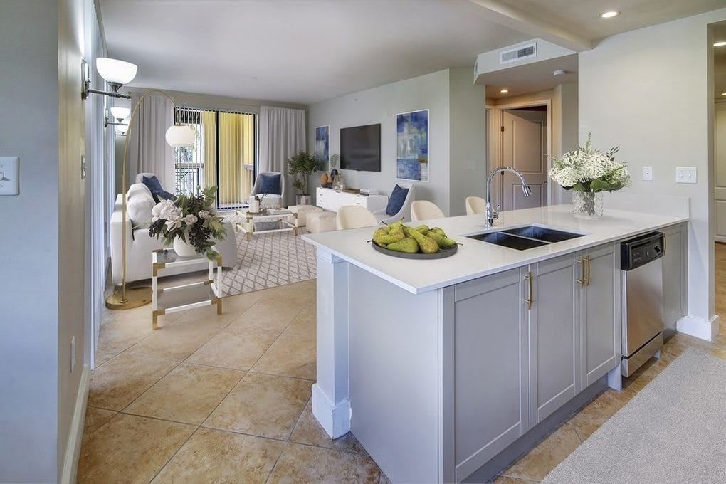 A modern open-plan kitchen and living room with elegant white decor.
