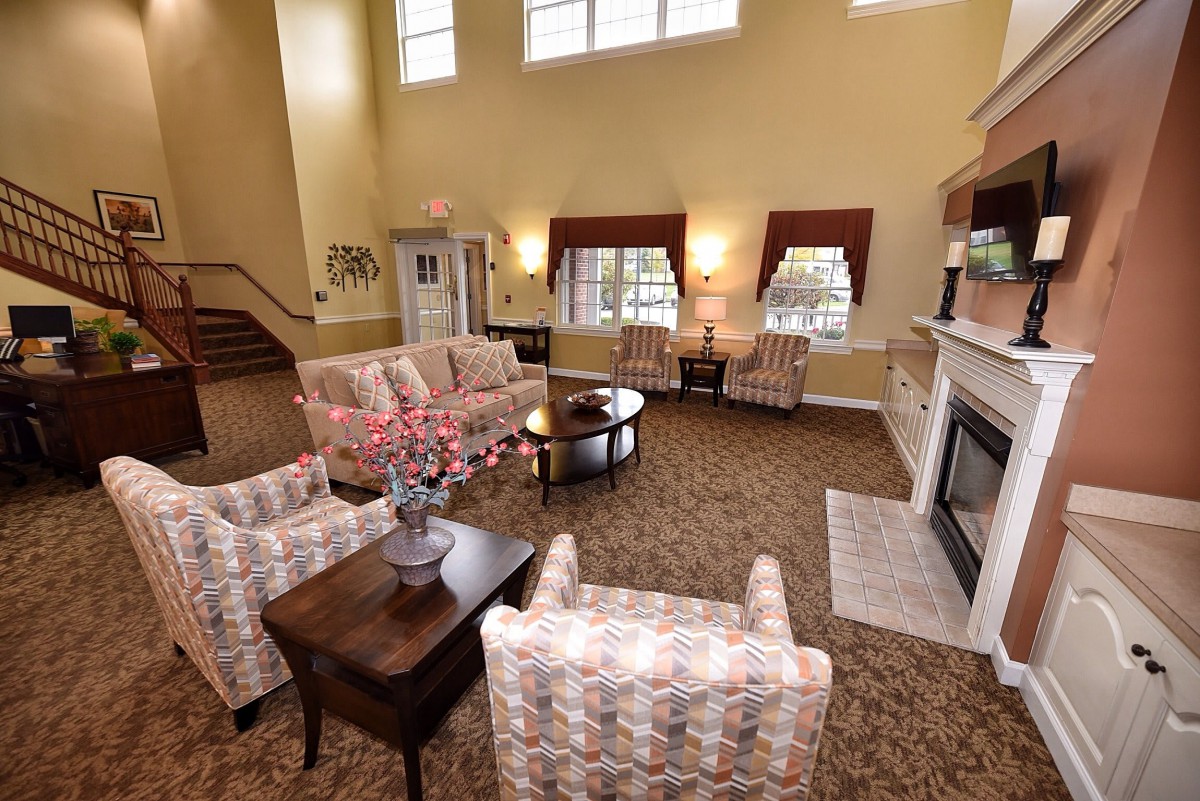 A spacious living room with comfortable seating, a fireplace, and large windows.