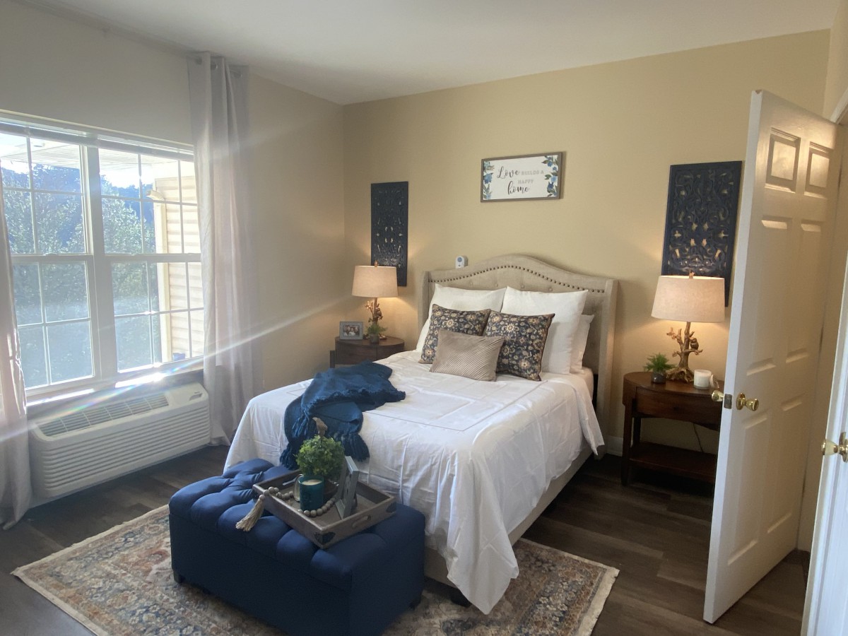 A cozy, well-decorated bedroom with natural light and elegant furnishings.