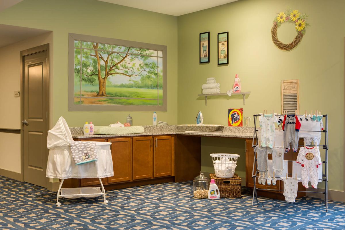 A vintage-style laundry room with wooden cabinets, a washing area, and decorative elements.