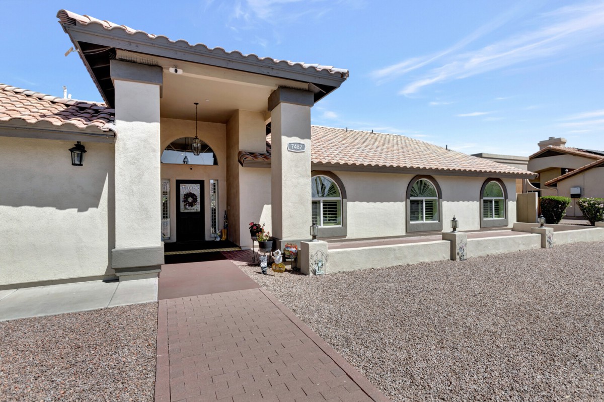 A modern residential house with an arched entrance and tiled roof.