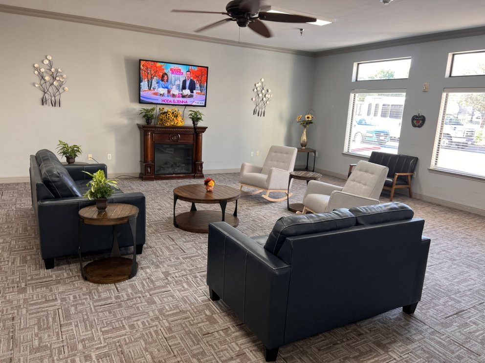 A cozy living room with sofas, a television, and a fireplace.