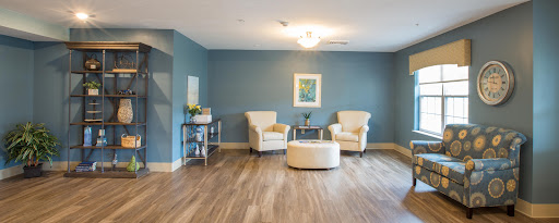 A cozy living room setup featuring stylish chairs and a modern coffee table against a serene blue wall.