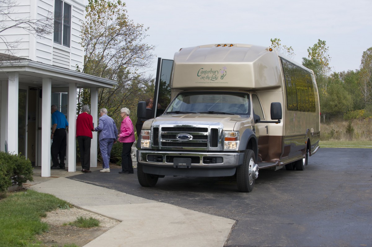 A group of people boarding a bus parked outside a building.