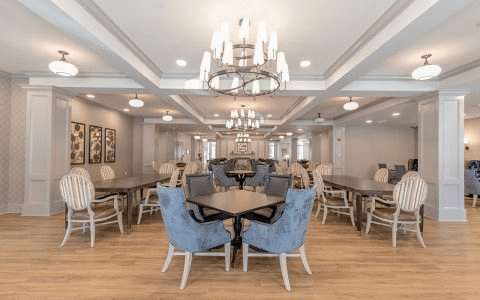 A modern dining area featuring elegant chandeliers, comfortable seating, and sleek tables.