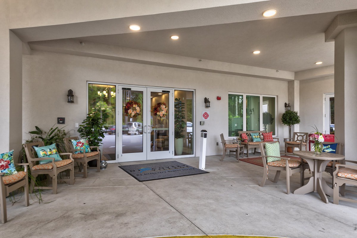 A welcoming entrance with outdoor seating and decorative plants.
