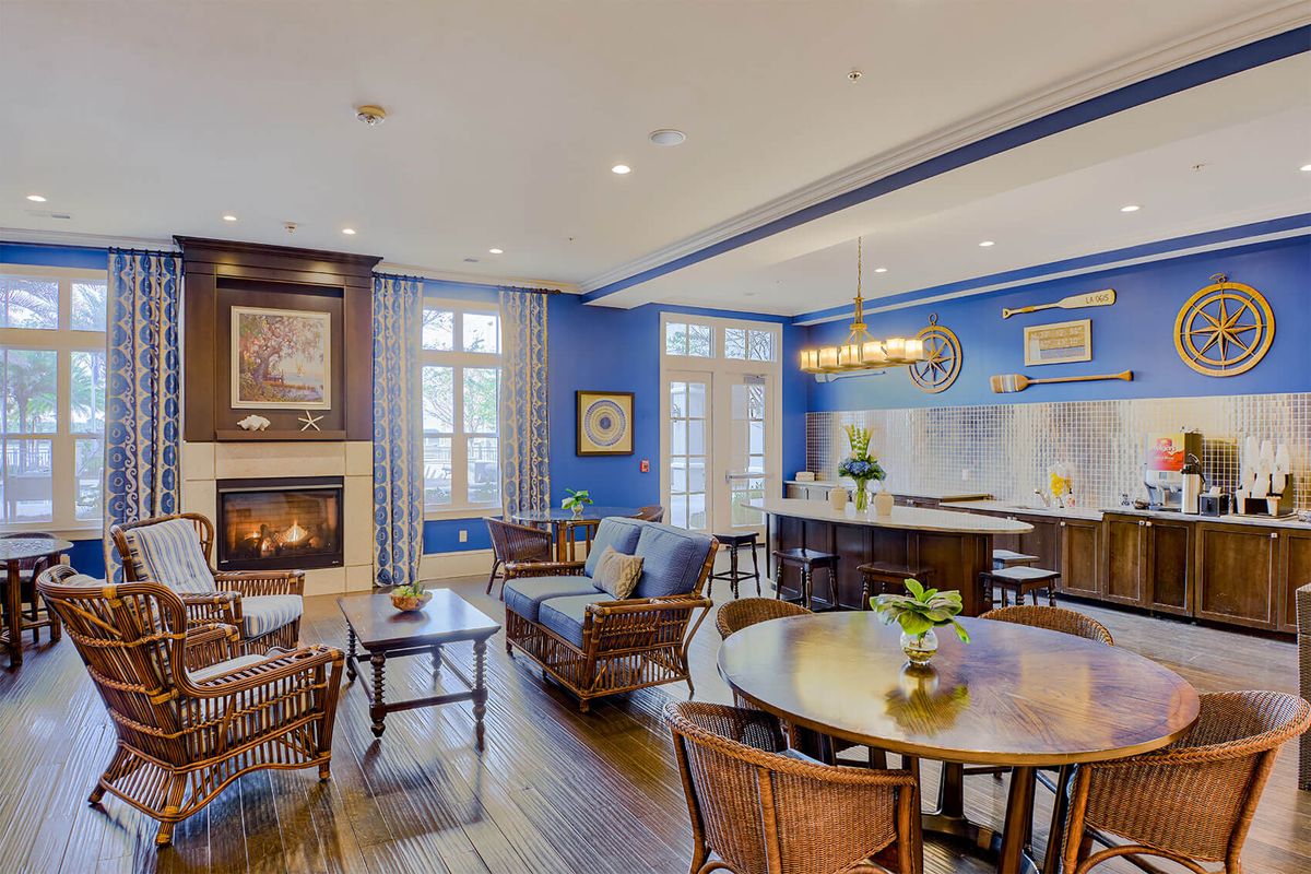 A modern open-concept living space featuring a cozy fireplace, blue walls, and elegant kitchen and dining areas.